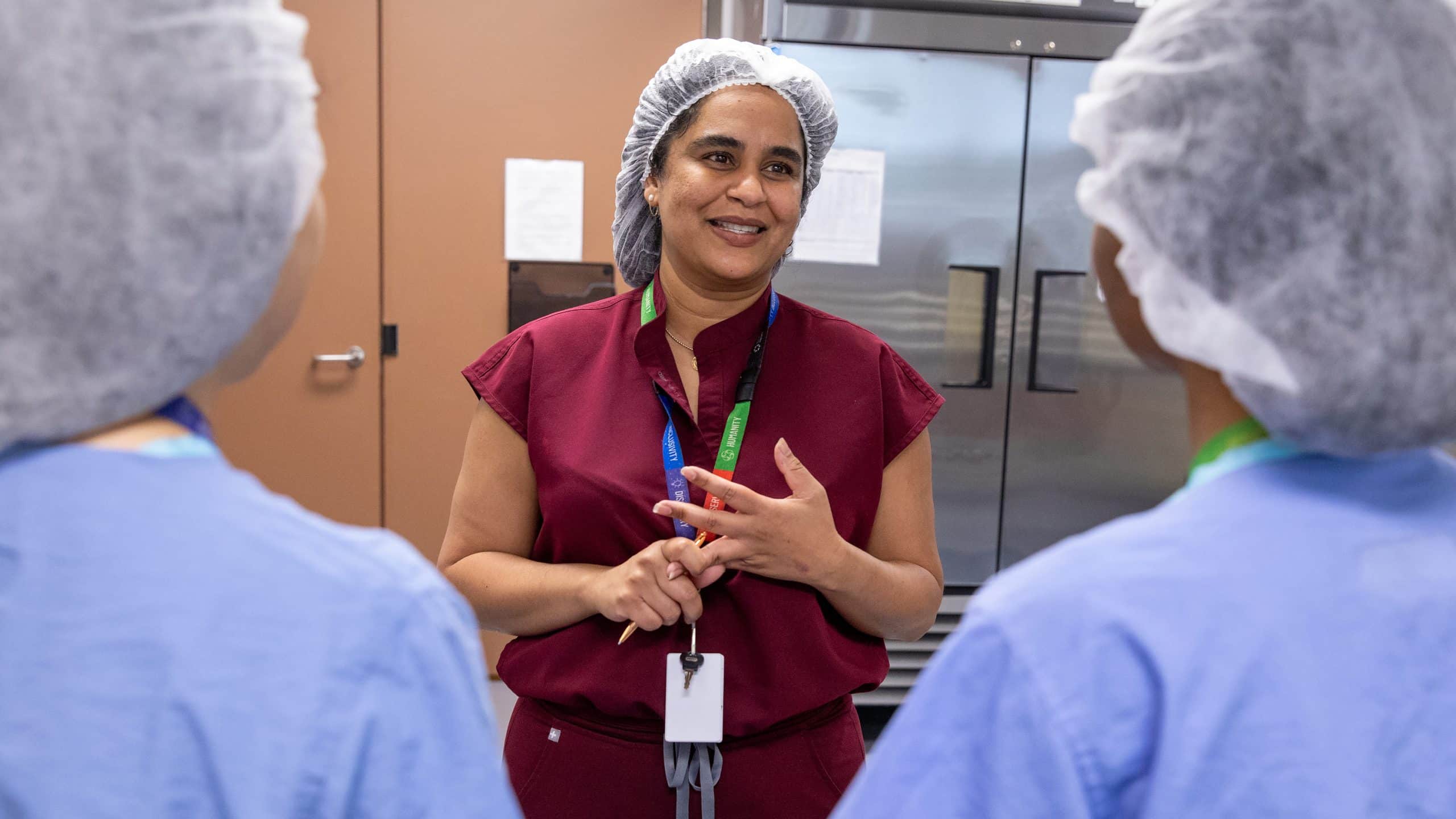 milk bank production supervisor speaking with team, smiling