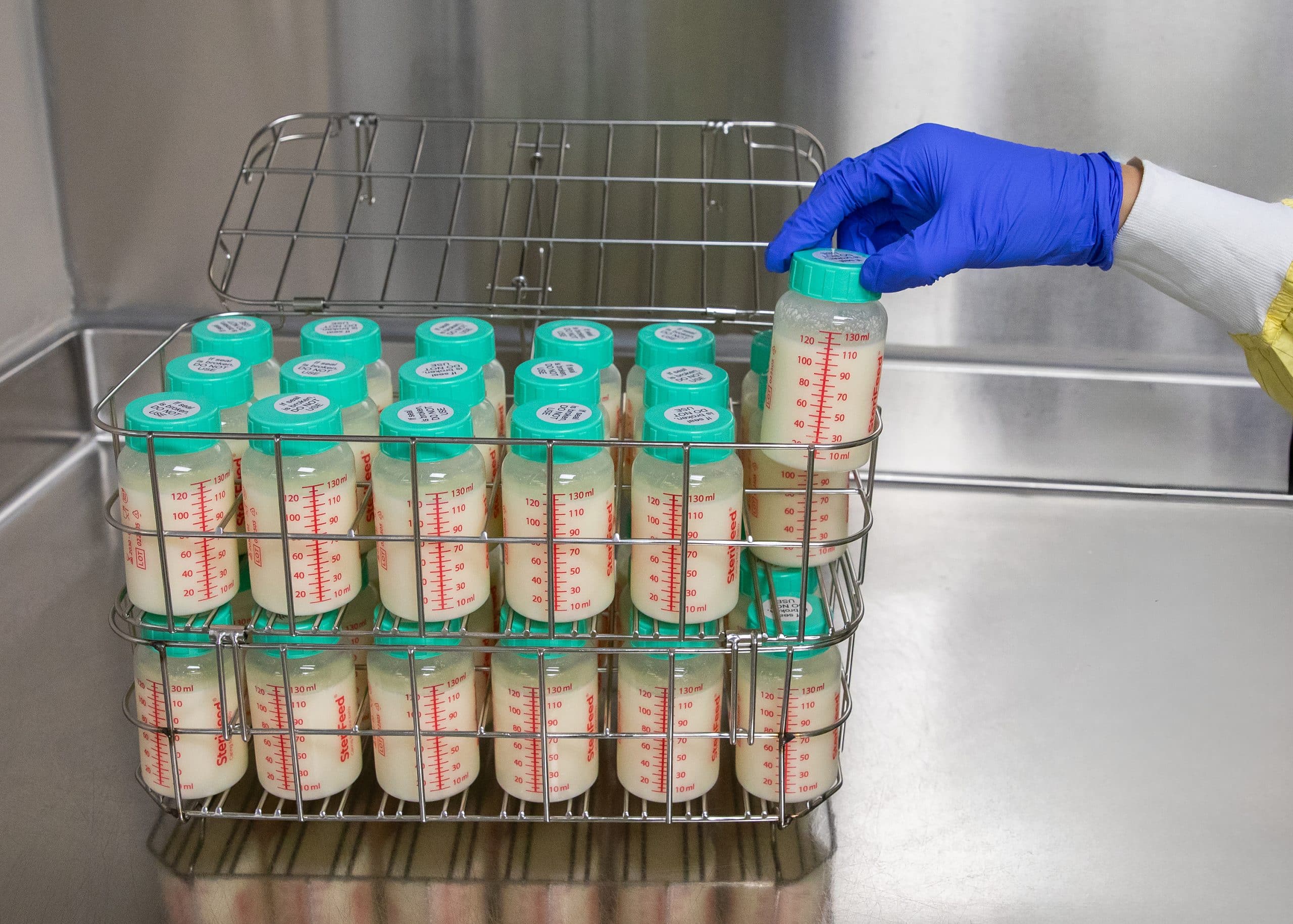 milk bank worker holding bottle of donor milk