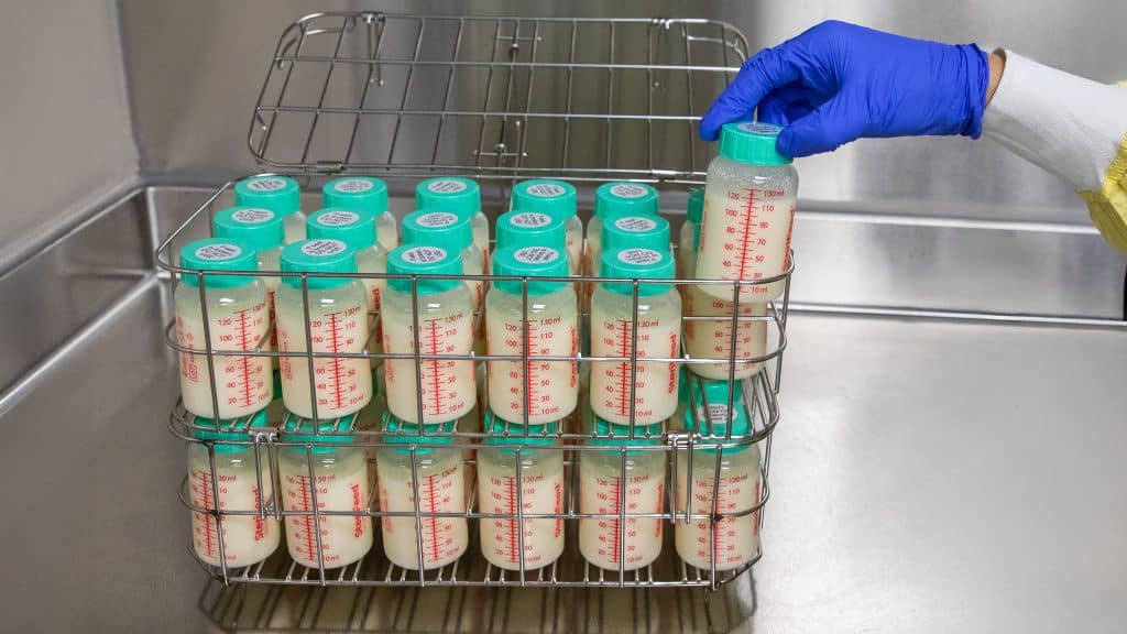 milk bank worker holding bottle of donor milk