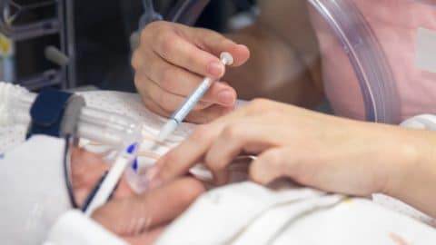 mother feeding nicu baby donor milk with syringe