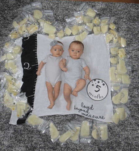 Twin babies lying on a blanket surrounded by bags of donor breastmilk